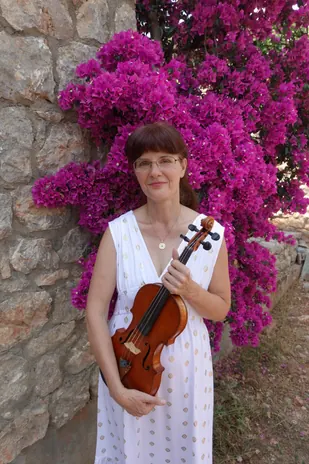 Katalin Kertész mit ihrer Violine vor blühender Bougainvillea